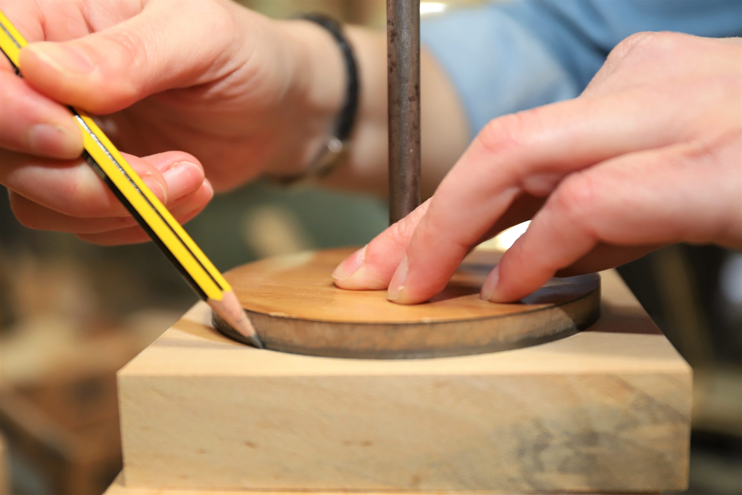 Manos de Isabel Neira e Atalanta Madera trabajando en una pieza de madera